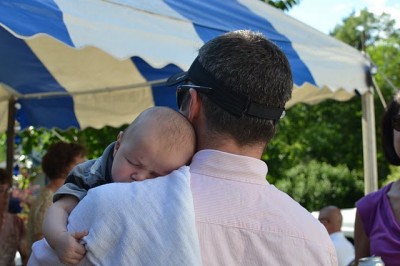 Exhausted after a busy day, sound asleep in dad's arms